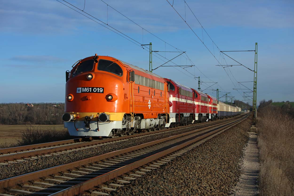 MAV Nosztalgia M61 019 + MAV Nosztalgia M61 020 + MAV Nosztalgia M61 001 + MAV Rt. PMLI Technologiai kozpont M61 017 + 8 MAV Nosztalgia coaches run uphil at Baracska (H) on their way from
Budapest-Kelenfld (H) to Tapolca (H) on 28 December 2019.